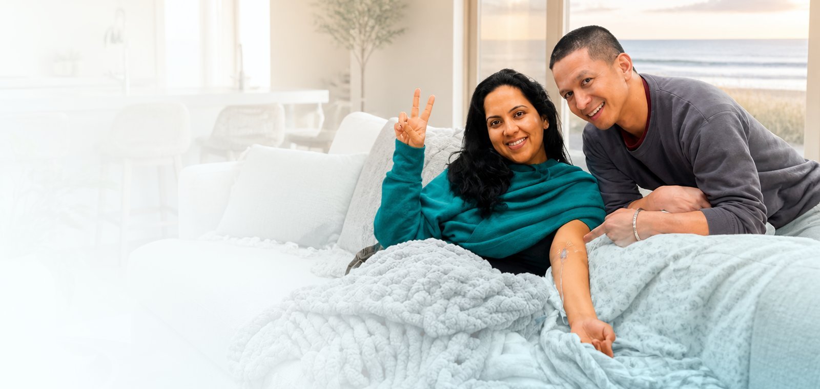 Smiling couple relaxing on a sofa at home during a mobile IV drip