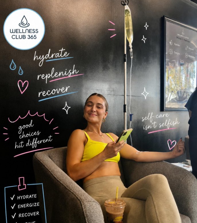 Patient relaxing during an IV drip beside a hydrate, replenish, recover chalkboard