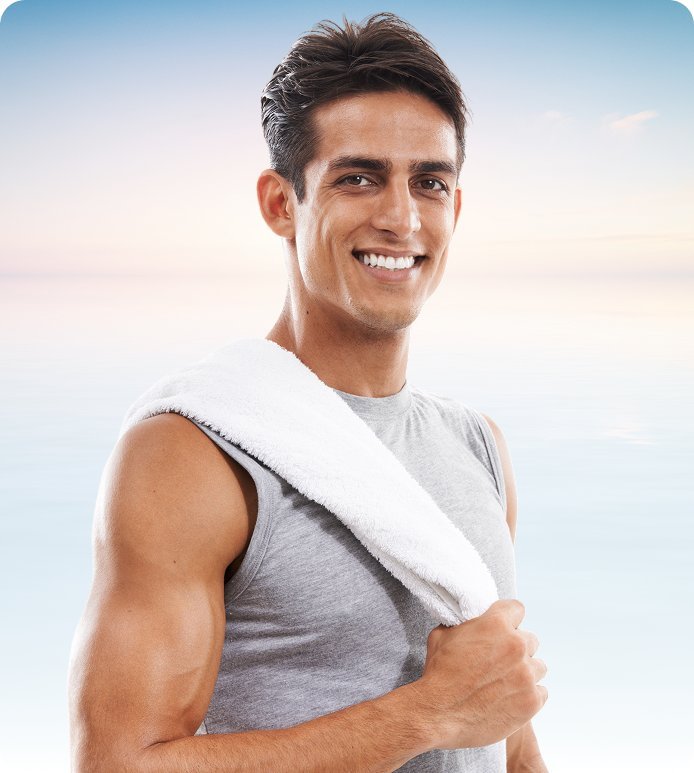 Smiling man with a towel over his shoulder after a workout